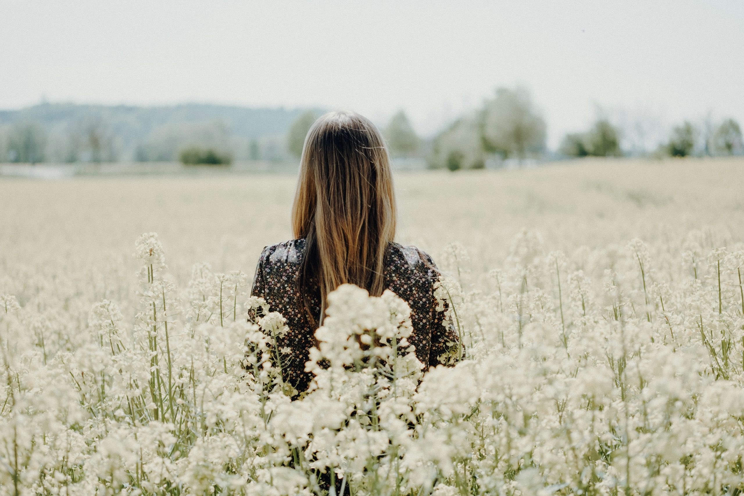 Woman walking serenely through a field in the sunshine